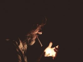 man with cigarette on his mouth holding lighter