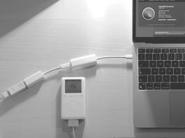 a white corded phone next to a laptop