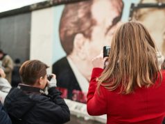 Политиката и менувањето на општеството a woman taking a picture of a man with a camera