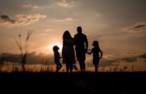 Насилството не се раѓа преку ноќ. Одговорност се учи од мали нозе a family standing in a field at sunset