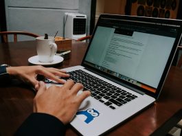 a person using a laptop on a wooden table